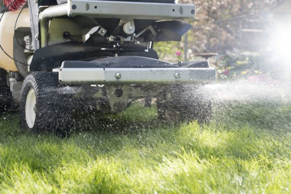 Ex-Mark Stand-On Sprayer lawn care applicator at work, spraying a lawn.