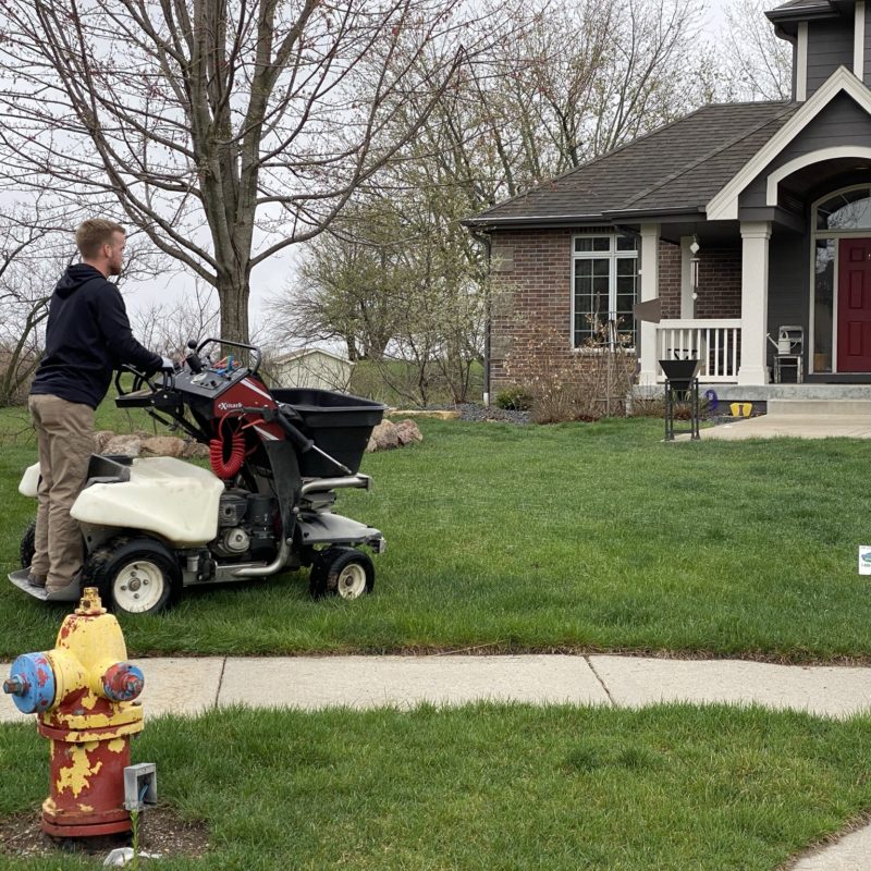 A PRO-TURF Services lawn care professional maintains a residential yard.