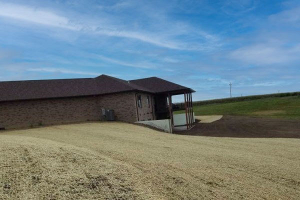 Home with lots of property in Iowa undergoing seeding and erosion control process.