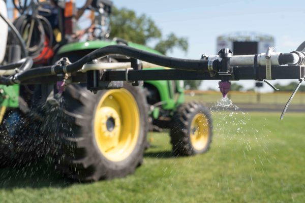 Spraying for weeds on a football field.